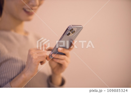リビングでスマホを見る女性 ナイトルーティーン リビングでスマホを見る女性 ナイトルーティーン 109885324