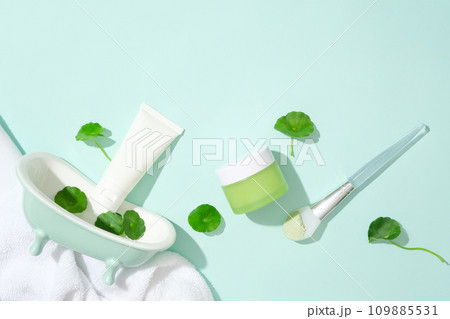 An unlabeled skincare set is displayed with fresh pennywort and props against a light blue background. Gotu kola helps reduce inflammation and redness caused by problems such as acne. An unlabeled skincare set is displayed with fresh pennywort and props against a light blue background. Gotu kola helps reduce inflammation and redness caused by problems such as acne. 109885531