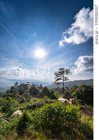 landscape and travel concept with sunlight and cloudy sky with camping tent on mountain 109886087