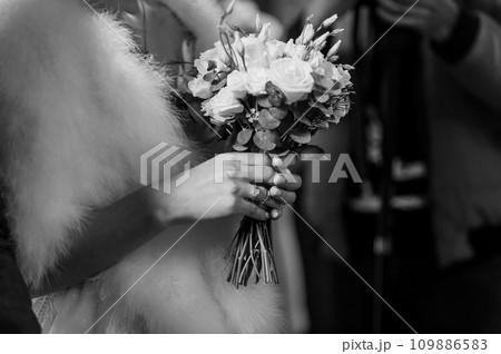 A beautiful wedding bouquet in the hands of the bride. Bouquet with white flowers in the hands of the bride 109886583