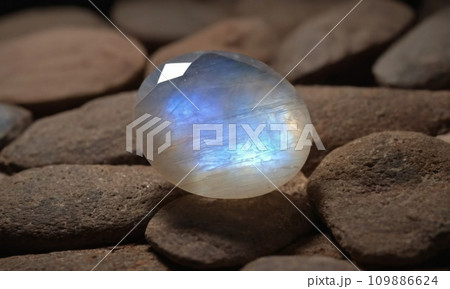 Natural precious moonstone on a brown background. Natural stone adularia 109886624