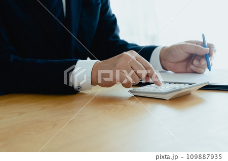電卓で計算するスーツ姿の男性の手元 電卓で計算するスーツ姿の男性の手元 109887935