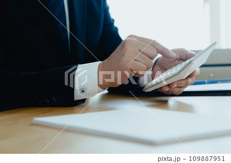 電卓で計算するスーツ姿の男性の手元 電卓で計算するスーツ姿の男性の手元 109887951