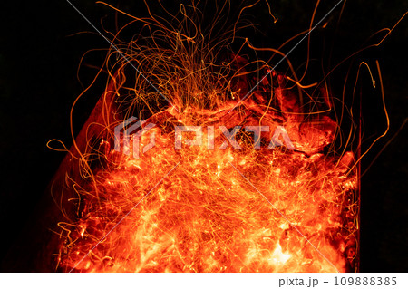 Top above overhead detail view od abstract hot red burning wooden coal background in bbq grill brazier or firepit at dark night time. Beautiful inferno heat sparks glowing flaming at hearth stove 109888385