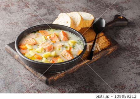 Lohikeitto, salmon fish soup with cream, potato, carrots, leek and dill closeup in a bowl. Horizontal 109889212