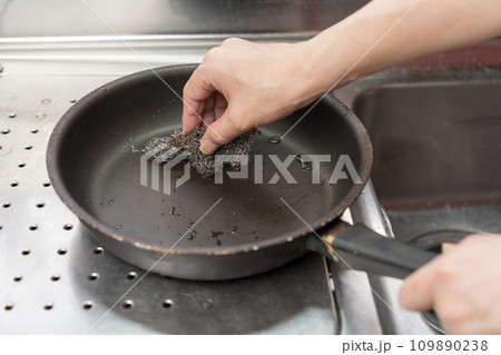 テフロン加工のフライパンを金たわしでこする男 テフロン加工のフライパンを金たわしでこする男 109890238