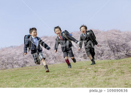 桜の咲く公園を走る一年生たち 109890636