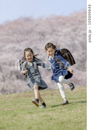桜の咲く公園を走る一年生たち 109890648
