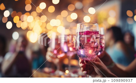 people in a party drinking glasses of sangria in background with colorful lights 109890937