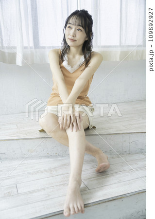 ラフな服装でくつろぐフェミニンな雰囲気の若い女性 109892927