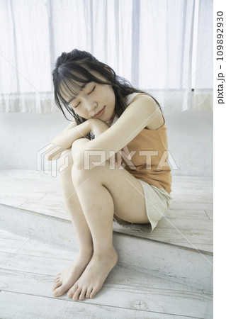 ラフな服装でくつろぐフェミニンな雰囲気の若い女性 ラフな服装でくつろぐフェミニンな雰囲気の若い女性 109892930