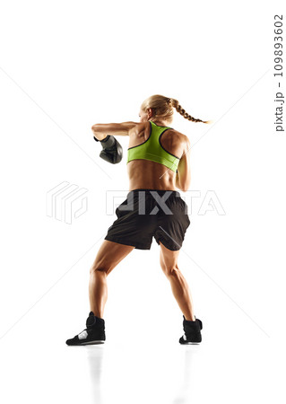 Muscular young woman, boxing athlete practicing, punching, training isolated over white background. Sport, healthy and active lifestyle 109893602