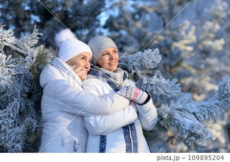 Happy women in winter clothes posing outdoors Happy women in winter clothes posing outdoors 109895204