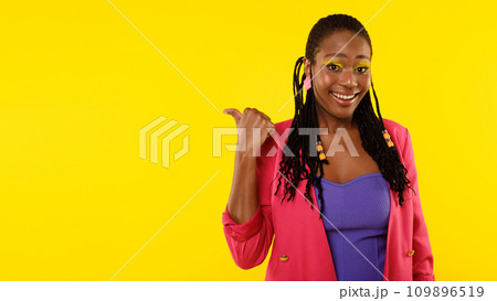 Black Female Pointing Thumb Aside At Blank Space, Studio Shot 109896519