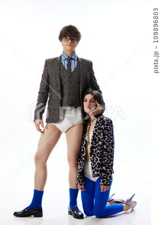 Unhealthy relationship. One of partner mentally tired stands on knees next to guy in costume but without pants, in underwear. Unhealthy relationship. One of partner mentally tired stands on knees next to guy in costume but without pants, in underwear. 109896803