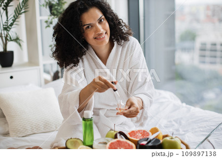 Beautiful African lady in dressing gown paints nails Beautiful African lady in dressing gown paints nails 109897138