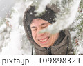 a boy is playing with snow on the street, it is snowing, a blizzard and frost on a winter day 109898321