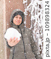 a boy is playing with snow on the street, it is snowing, a blizzard and frost on a winter day 109898324