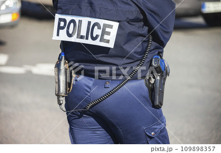 French police lady with "POLICE" written on the back of her uniform. French police lady with "POLICE" written on the back of her uniform. 109898357