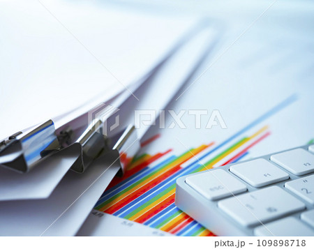 テーブルに置かれたグラフと書類とキーボード 109898718