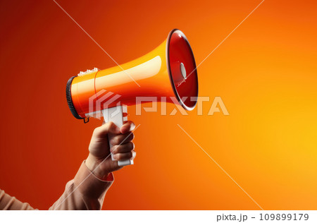 Megaphone in hand on a orange background, attention concept announcement 109899179