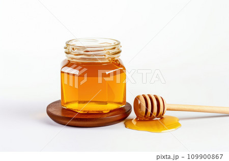 glass jar full of honey and dipper isolated on white background 109900867