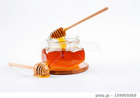 glass jar full of honey and dipper isolated on white background glass jar full of honey and dipper isolated on white background 109900868