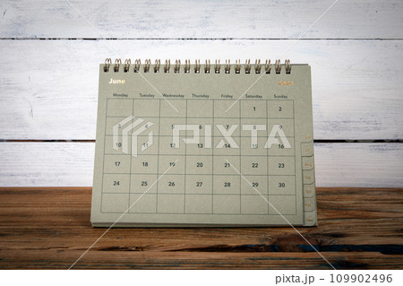 JUNE 2024 cardboard desk calendar and planner on a wooden texture table JUNE 2024 cardboard desk calendar and planner on a wooden texture table 109902496
