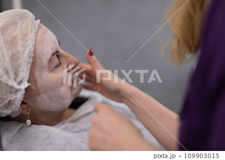 An elderly woman relaxes in a beauty salon. 109903015