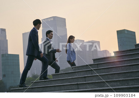 team of asian corporate executives walking in central business district team of asian corporate executives walking in central business district 109903184