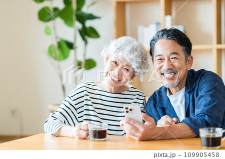 一緒にスマホを見ているシニア夫婦。 109905458