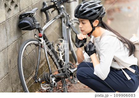ロードバイクのパンクトラブルに困る若い女性 ロードバイクのパンクトラブルに困る若い女性 109906083