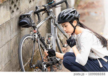 ロードバイクのパンクトラブルに困る若い女性 109906088