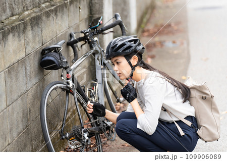 ロードバイクのパンクトラブルに困る若い女性 109906089