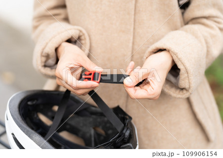 サイクリングヘルメットのあご紐の長さを調整している若い女性 109906154