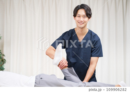 施術を行う若い男性マッサージ師 109906282