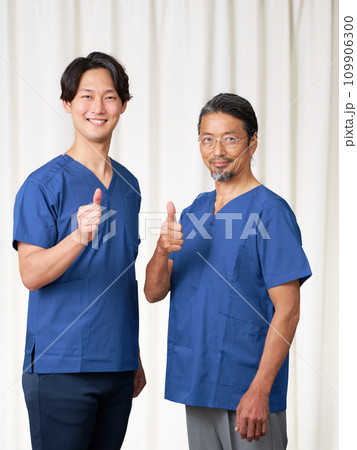 笑顔で視線を向けるスクラブ姿の男性スタッフ 109906300