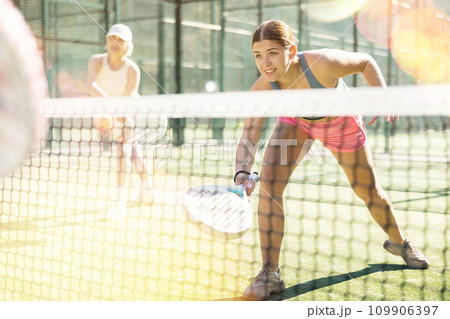 Young sporty woman playing padel game in court on sunny day 109906397