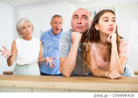 Portrait of an offended couple, which mature family members reprimand Portrait of an offended couple, which mature family members reprimand 109906430