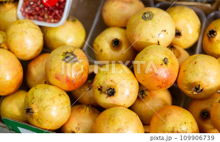 Store assortment offers peeled fruit core, pomegranate seeds in containers and whole pomegranate 109906739