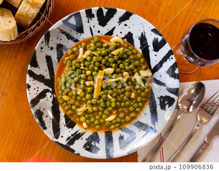 Green peas stewed with pieces of squid in appetizing gravy 109906836