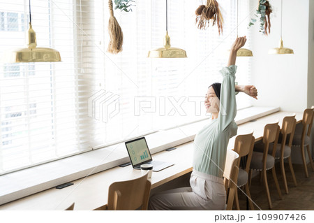 デスクワークしながらストレッチをする女性 109907426