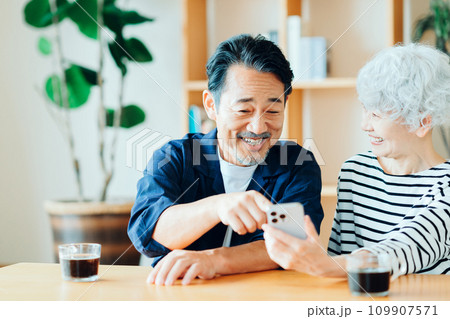 一緒にスマホを見ているシニア夫婦。 109907571
