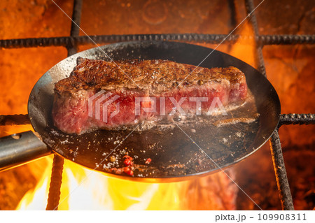 ワイルドステーキ　Grill a steak over an outdoor 109908311