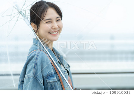 雨の中お出かけする女性 梅雨時期に旅する女性 雨の中お出かけする女性 梅雨時期に旅する女性 109910035