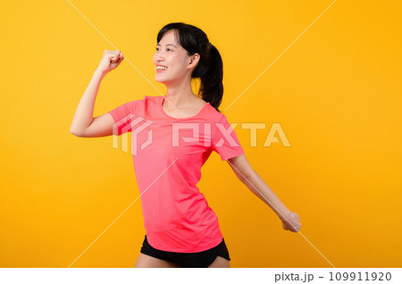 Portrait beautiful young asian sports fitness woman happy smile wearing pink sportswear posing exercise training workout isolated on yellow studio background. wellbeing and healthy lifestyle concept. 109911920