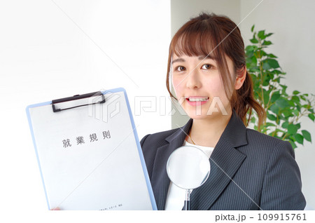 就業規則とルーペを持つ女性 109915761