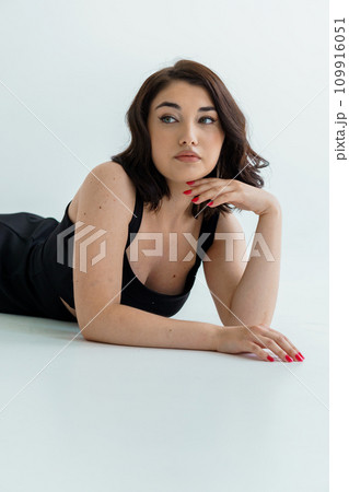 Portrait of a young beautiful girl in a black dress on a white background Portrait of a young beautiful girl in a black dress on a white background 109916051