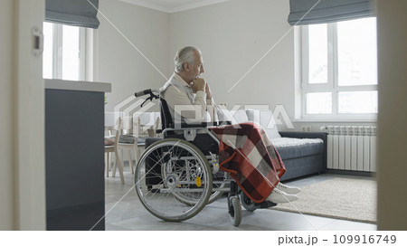 Unhappy senior man in wheelchair feeling sad, life with disability, nursing home 109916749