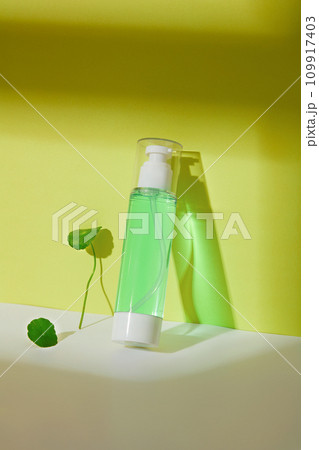 Close-up of a toner bottle containing light green liquid with pennywort extract. The concept of homemade cosmetics from natural ingredients - safe for the skin. 109917403